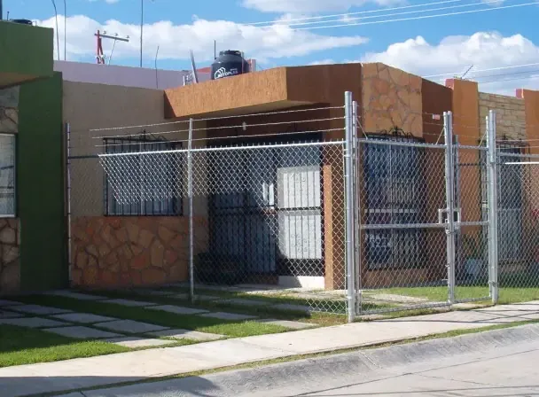 Cerca de malla ciclónica galvanizada con puertas en una casa